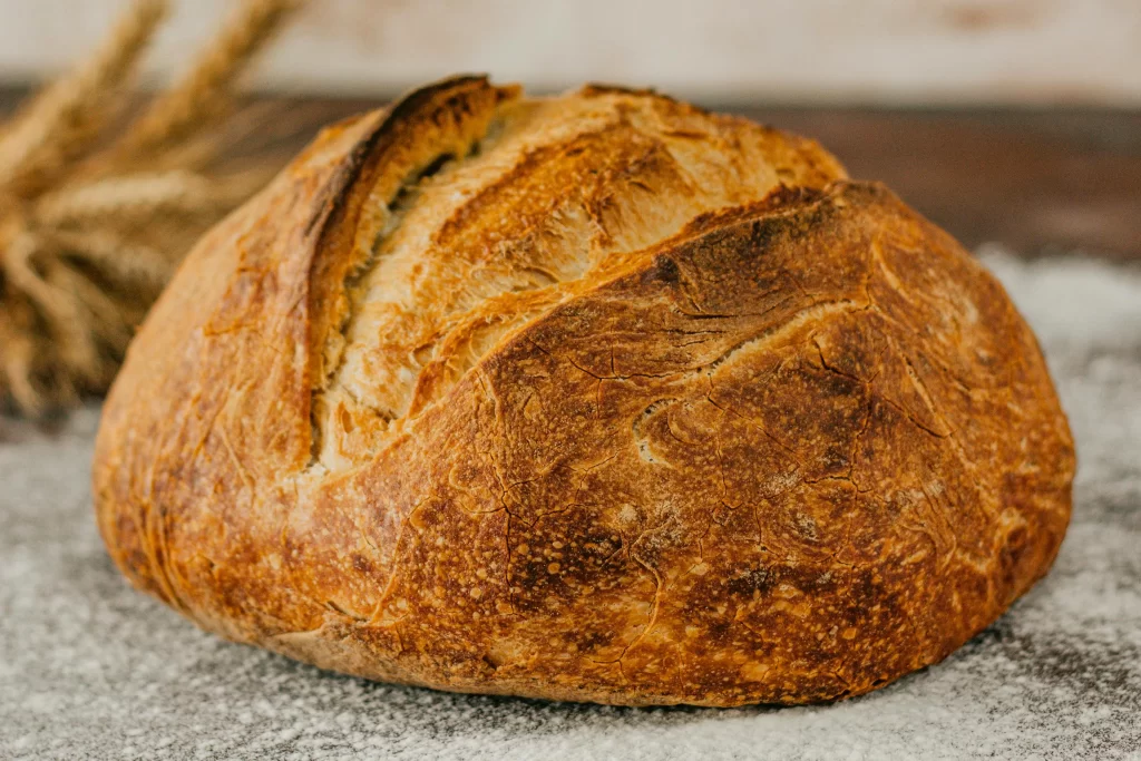 A loaf of baked bread sits on a stone counter.