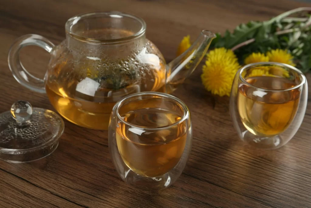 Tea service sits on a wooden table, in clear glass serve ware.