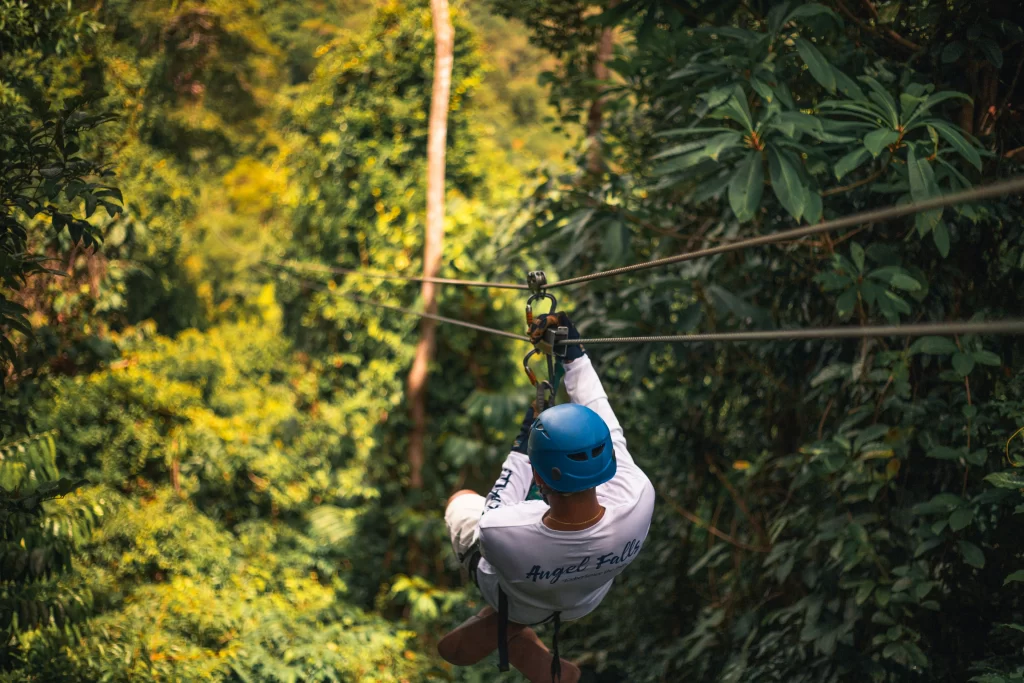 A man zip-lines through the jungle canopy in Belize.