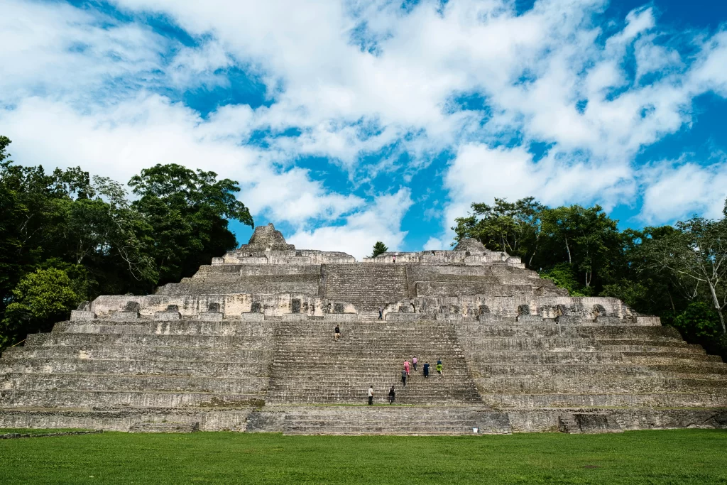 Visitors climb the stone steps of the massive Caana temple in Caracol, Belize.