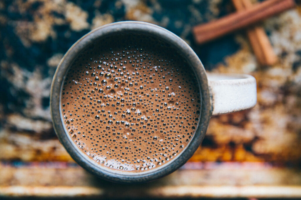 Close-up of an earthen mug of hot cacao.