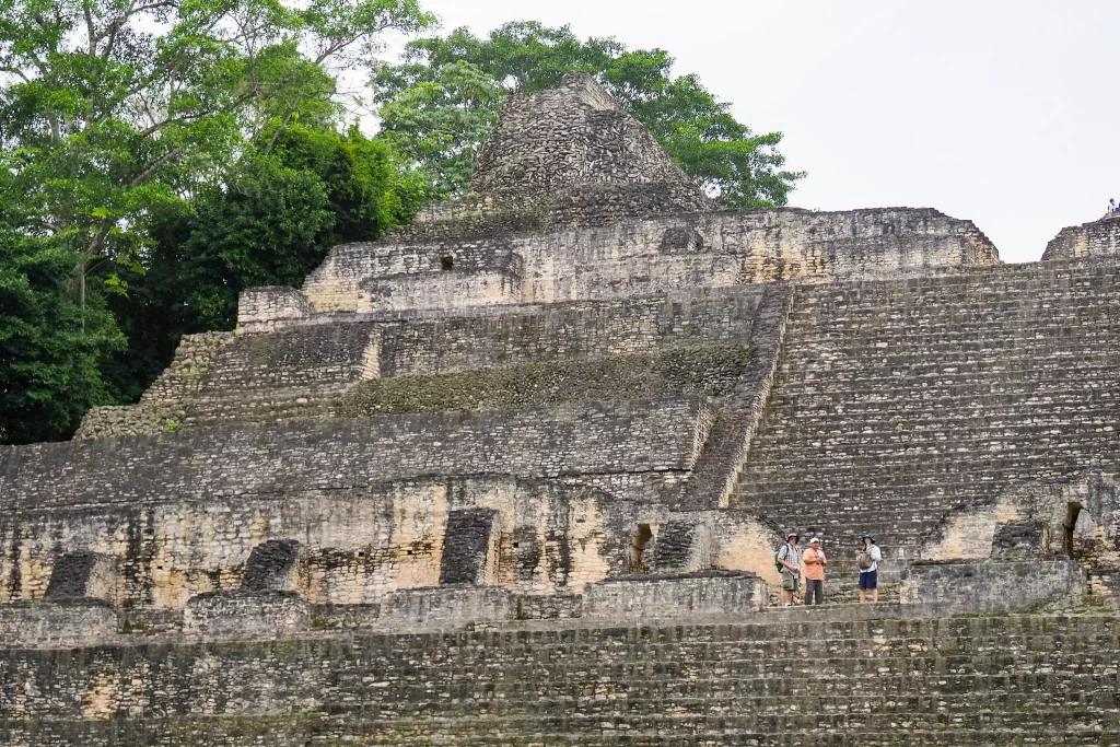 Visitors stand halfway up the steps of the ancient Mayan temple of Caana, in Caracol, Belize.