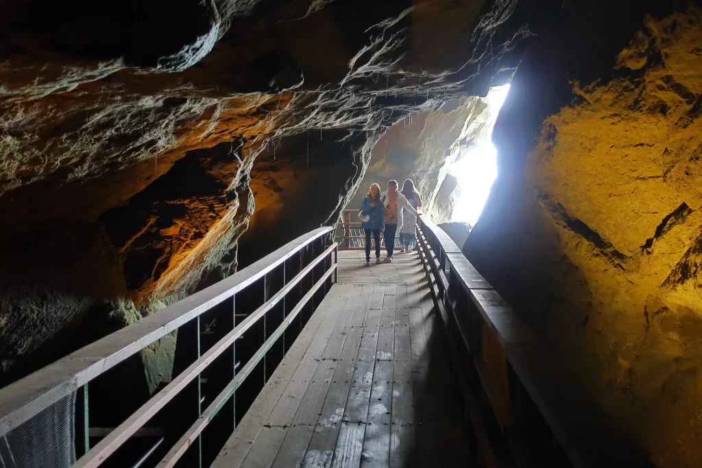 Visitors walk along the wooden pathway inside Sunny Jim's Sea Cave in La Jolla, California. Sunny Jim's is one of the more unique things to do in La Jolla with kids.