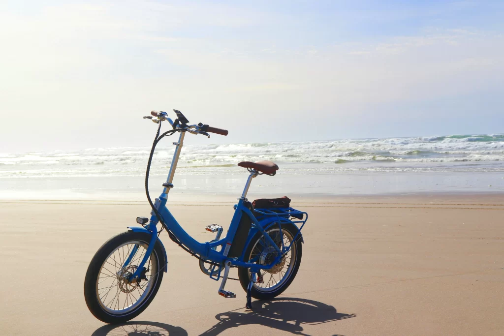 A bike stands on a beach against a backdrop of waves.
