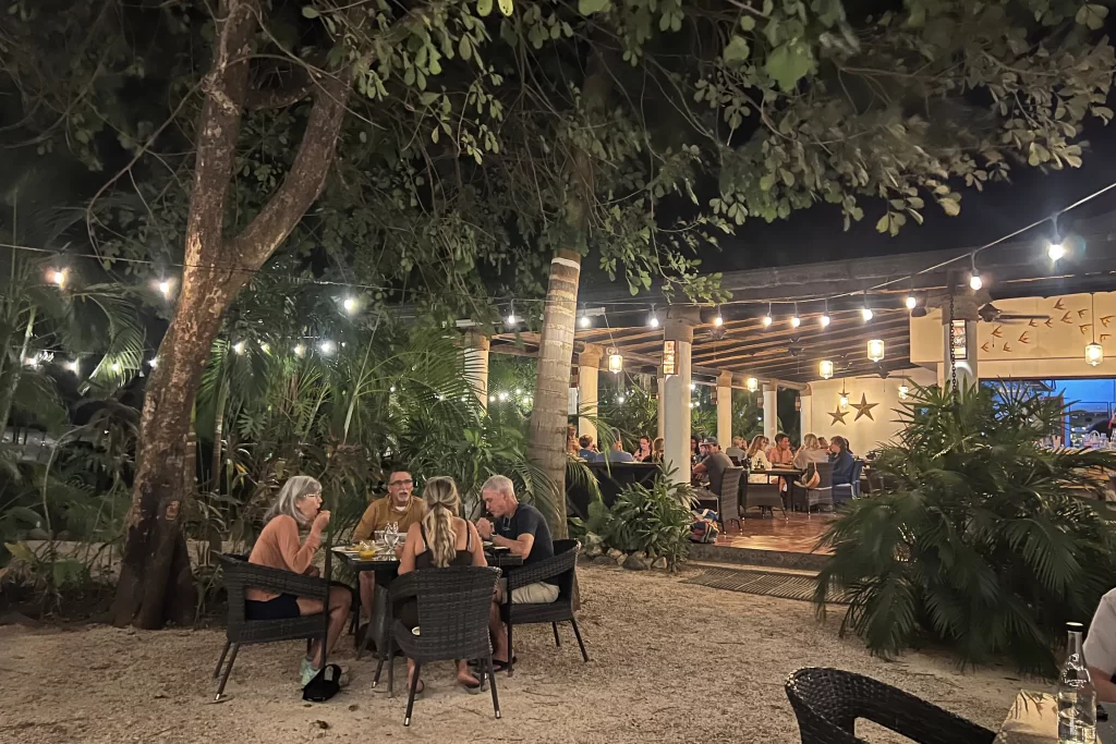 Diners sit beneath trees at the open-air Pacifico Azul restaurant. It's one of the more popular restaurants in Nosara for a sit-down seafood dinner.