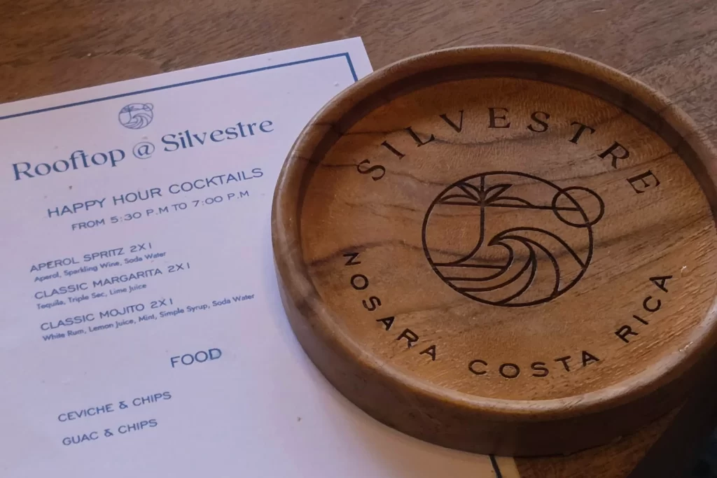 Closeup of a wooden coaster and happy hour menu at Silvestre in Nosara, Costa Rica.