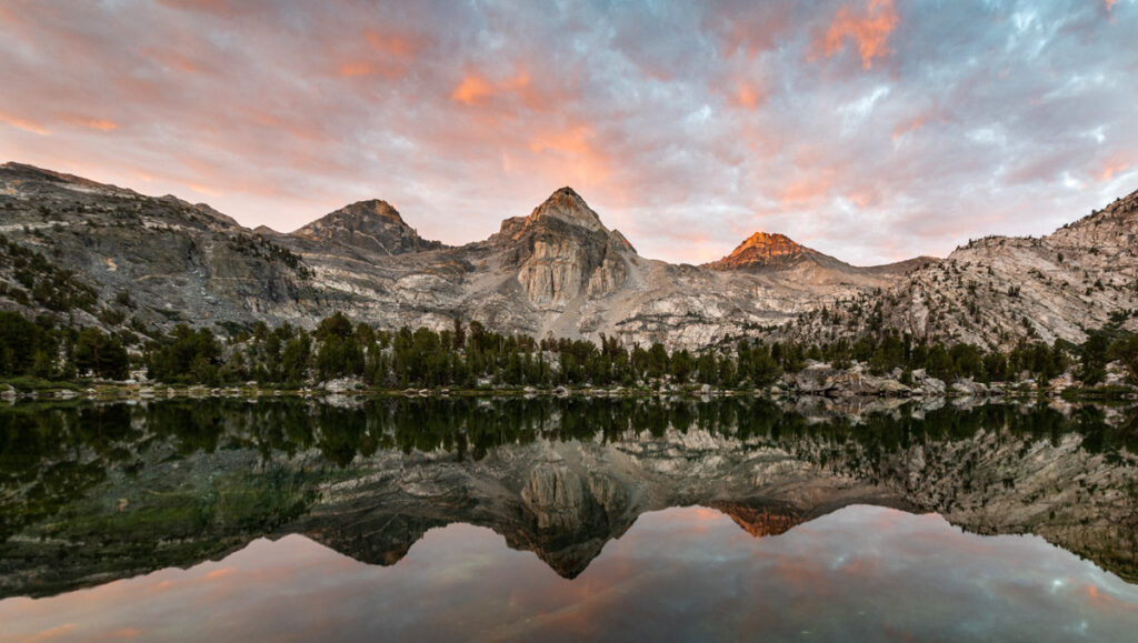 Middle Rae Lake, in Kings Canyon National Park, is awash with color at sunrise, with the mountain peaks reflecting on the waters.