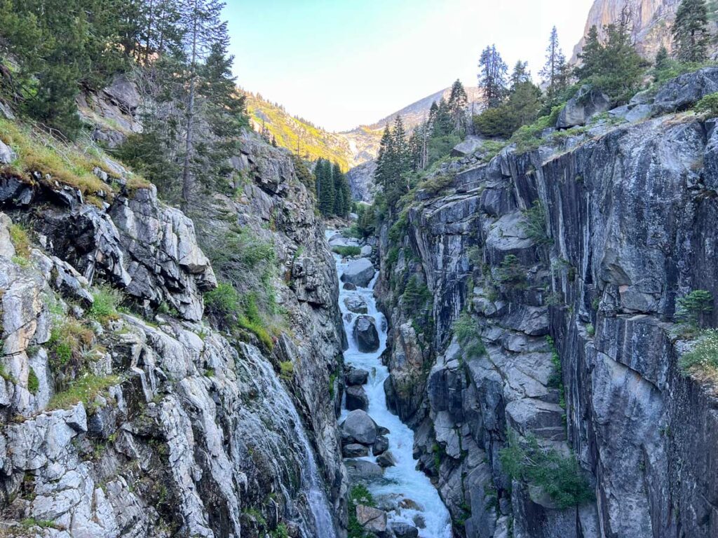 A hiker's view crossing the bridge over Lone Pine Creek on the High Sierra Trail, looking back up the granite gorge. 