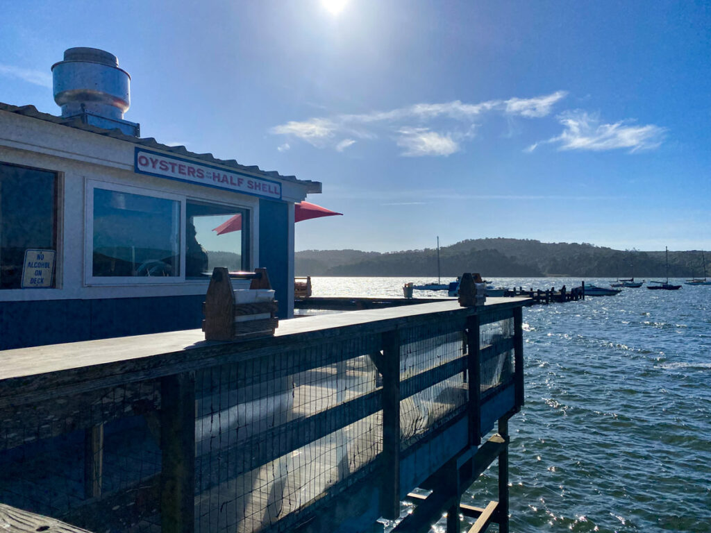 The wooden deck of the historic Marshall Store looks out over Tomales Bay on a sunny day in Marin County, California.