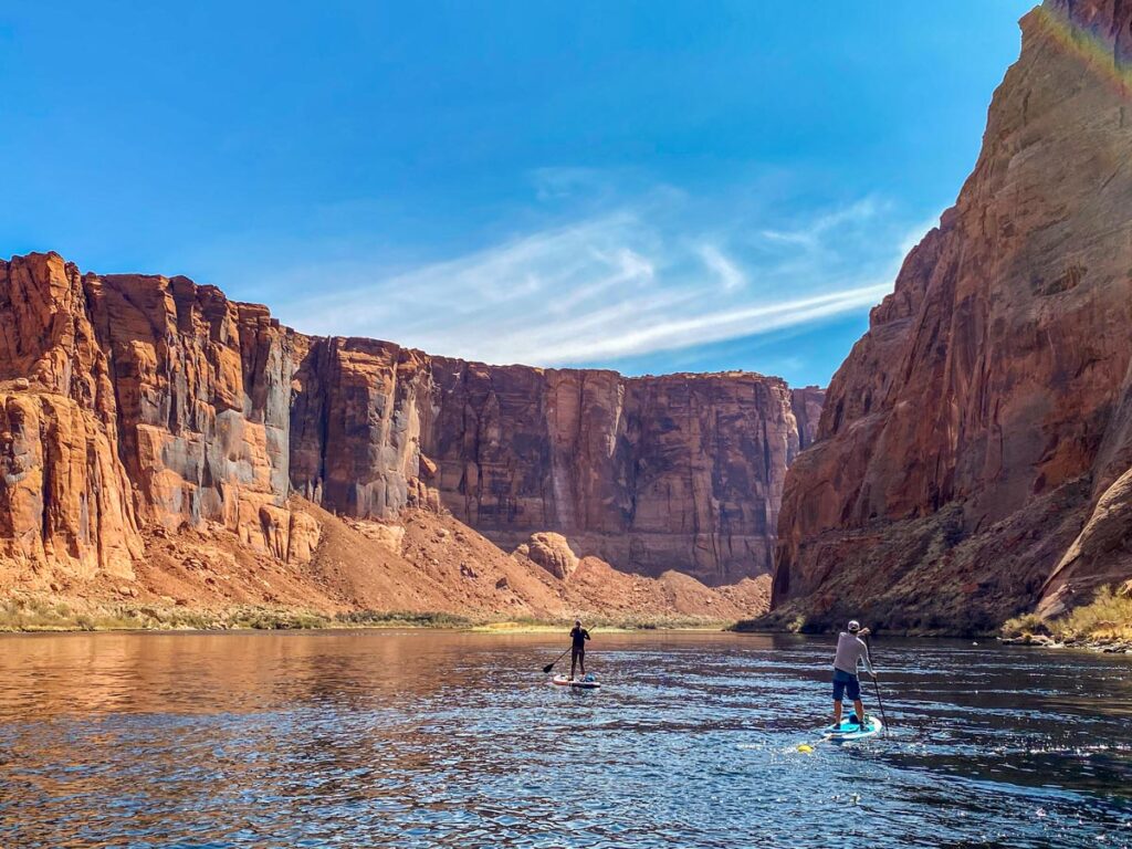 Paddleboarding Horseshoe Bend: two lone individuals are silhouetted against Marble Canyon along the Colorado River.