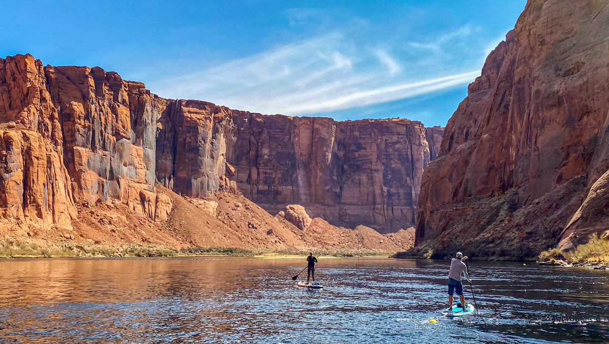 Paddle boarding Horseshoe Bend: two lone individuals are silhouetted against Marble Canyon along the Colorado River.