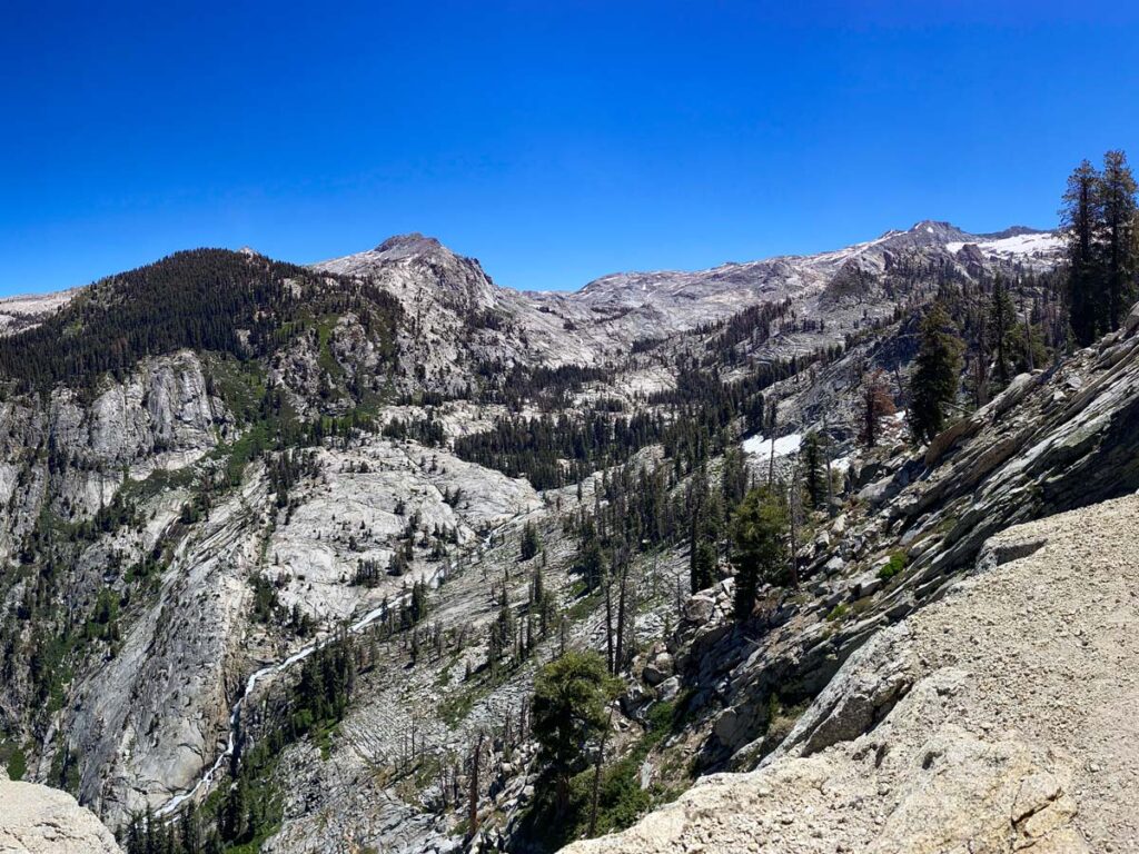 The Watchtower looks out across a valley to granite domes and conifer trees. The panoramic views make the Watchtower trail one of the best moderate hikes in Sequoia National Park.