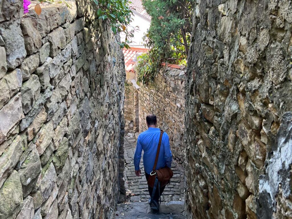 A tourist strolls through the narrow medieval streets of Piran, Slovenia.