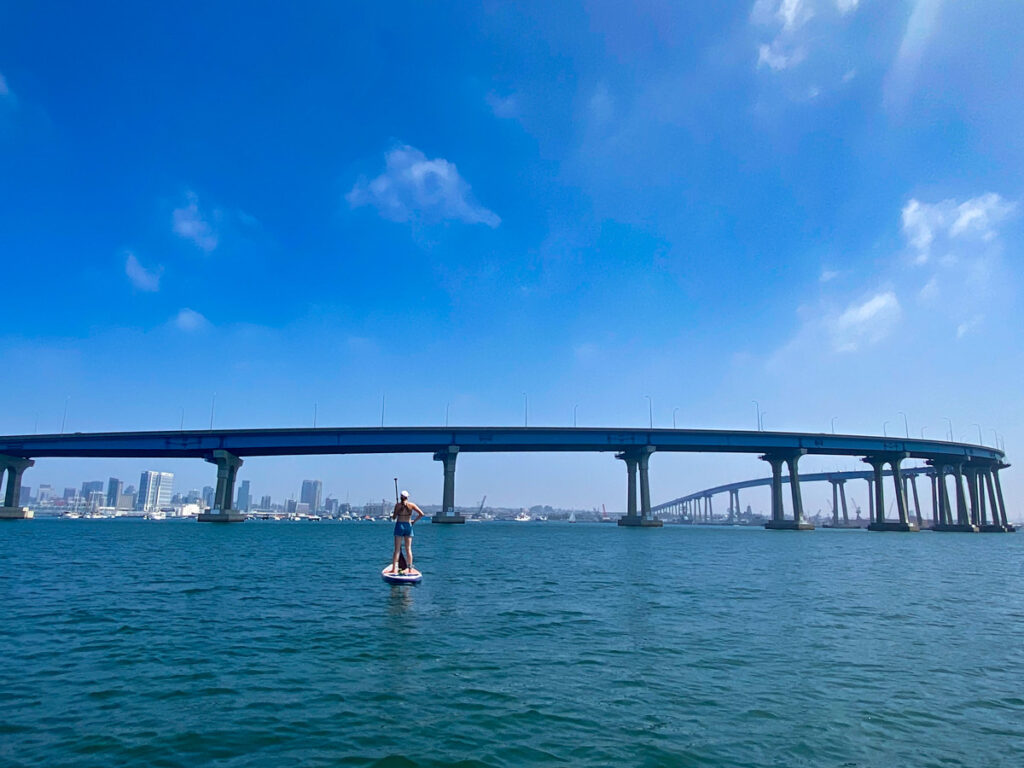 A lone paddle boarder in front of the Coronado Bay Bridge in San Diego.