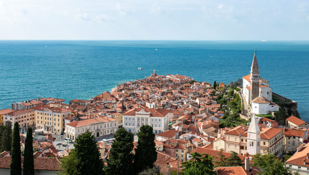 The bright terracotta roofs of Piran, Slovenia, silhouetted against the Adriatic Sea.