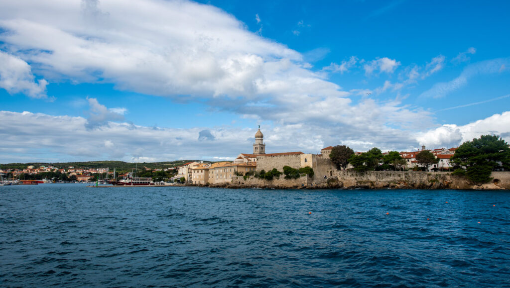 The walled old town of Krk, Croatia is visible from across the small harbor.