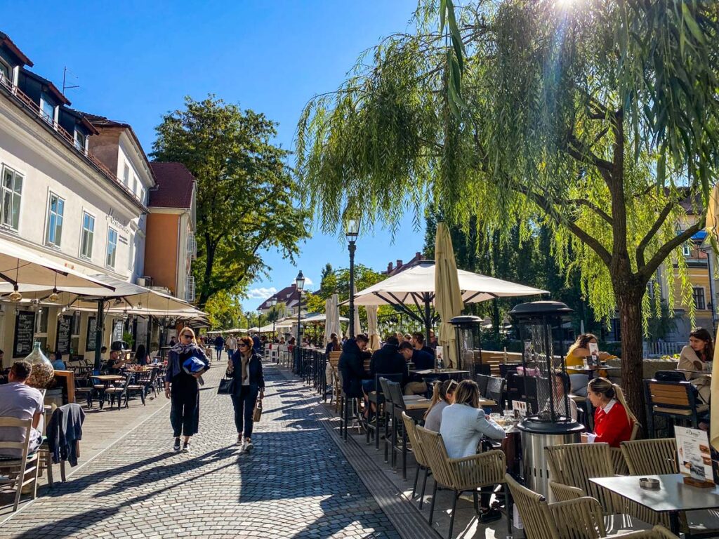 Pedestrians walk along the Cankerjevo Quay promenade in Ljubljana, Slovenia.