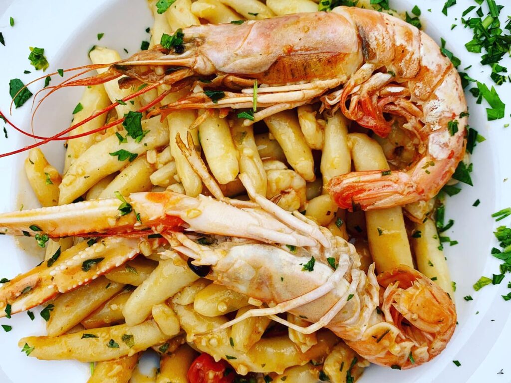 Šurlice, a coiled noodle pasta native to Krk, Croatia, is prepared with fresh prawns and parsley.