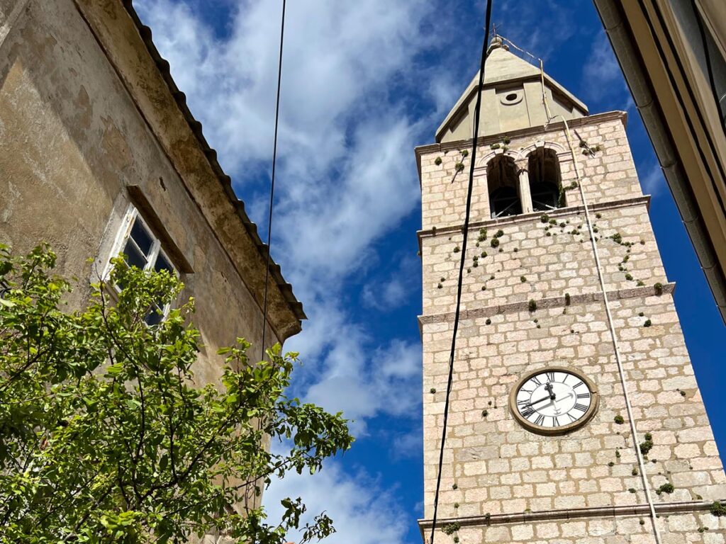 The medieval clock tower in Vrbnik, Croatia as seen from street level below.