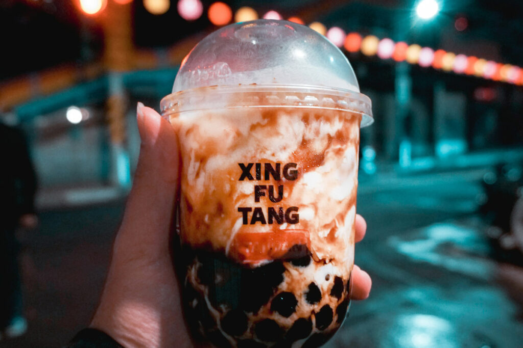 Xing Fu Tang boba tea is silhouetted against a nighttime street scene in Taipei, Taiwan.