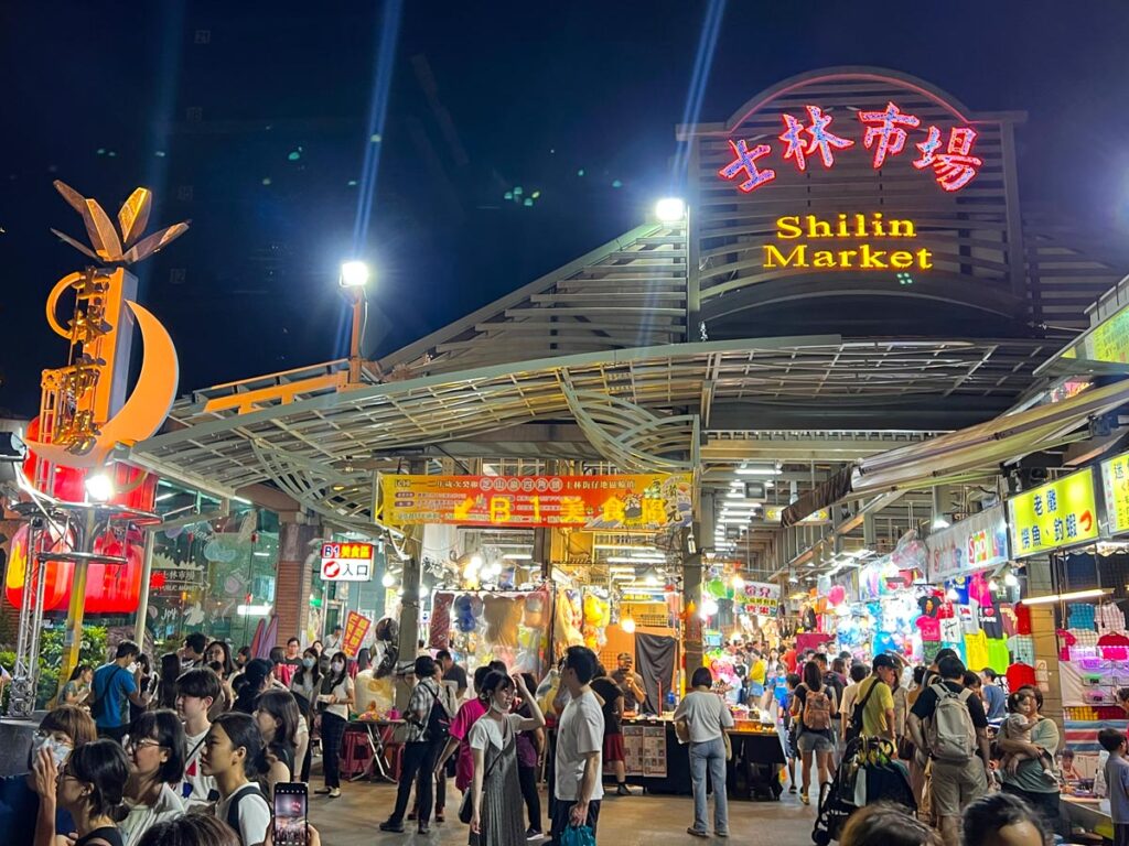 Pedestrians gather outside Shilin Night Market in Taipei, Taiwan.