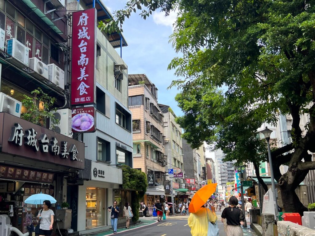 Pedestrians walk along Yongkang Street in Taipei, Taiwan on a sunny day.