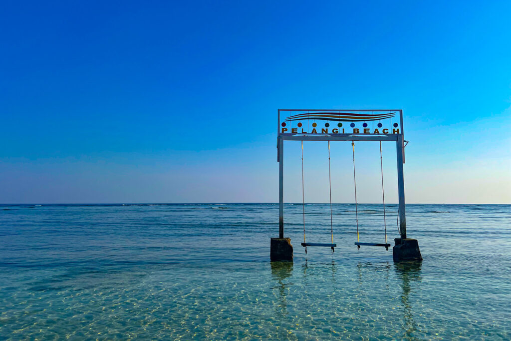 Two beach swings stand in the water off Pelangi Beach, one of the best beaches on Gili Air for beach swings. 