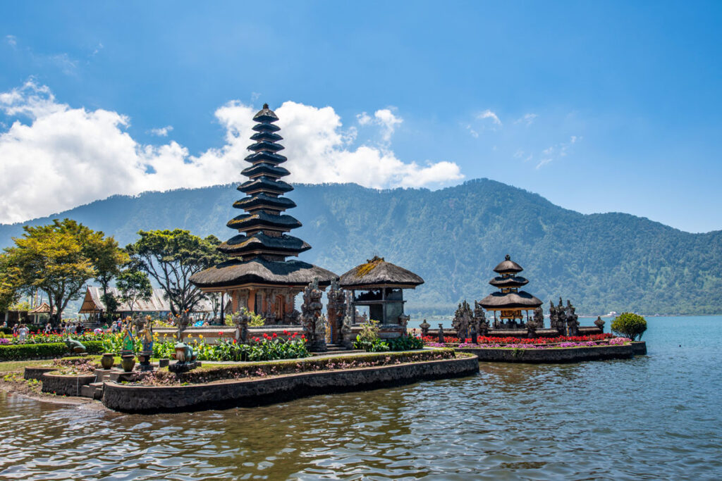 Ulun Danu Temple on Bali, Indonesia is visible from the shoreline on a sunny day. The temple is one of the most photographed spots on Bali, and is often a day trip for those spending 4 days in Ubud or more. 