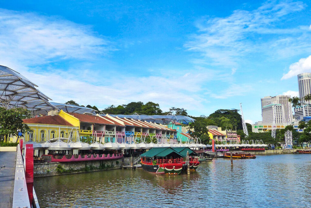 Brightly painted buildings line the waterfront of Clarke Quay on a sunny day in Singapore