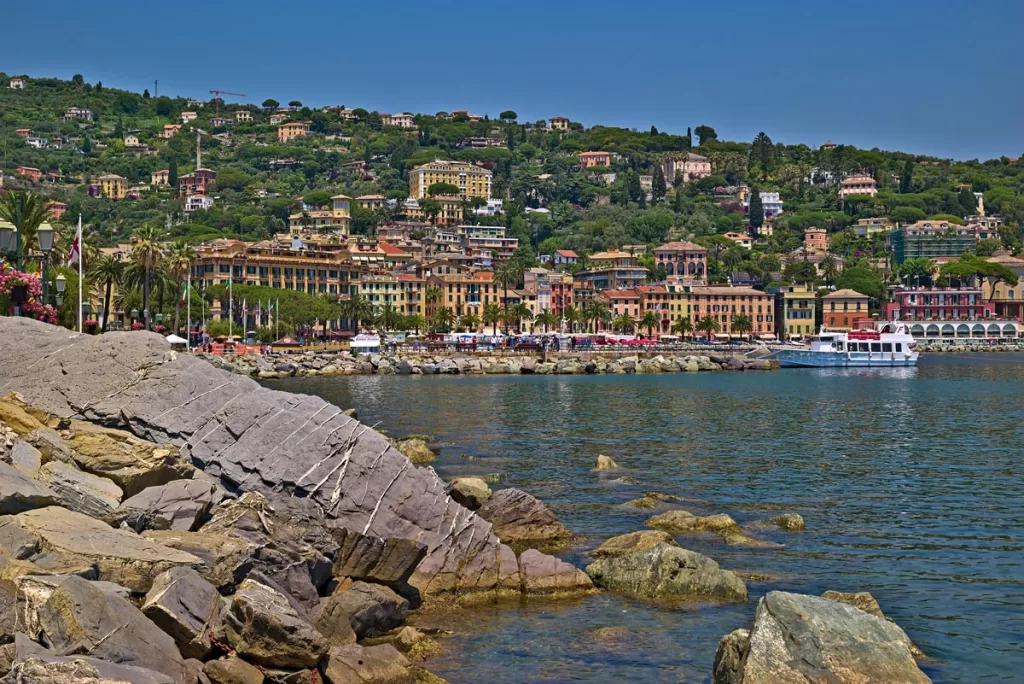 The seaside town of Santa Margherita, Italy, stretches along a crescent-shaped harbor with pastel buildings lining the waterfront.