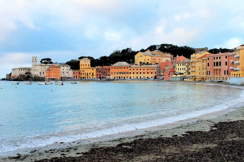 Brightly-colored buildings line the crescent-shaped harbor of Sestri Levante in Liguria, Italy.