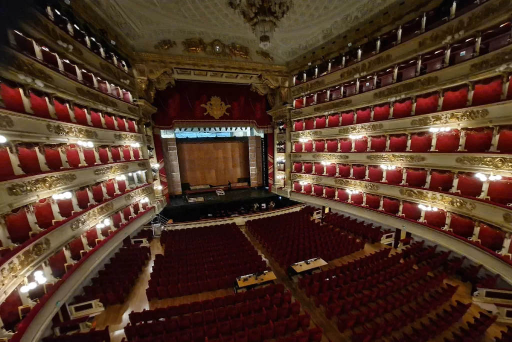 Lights illuminate the red velvet seats and boxes of La Scala Opera House in Milan, Italy.