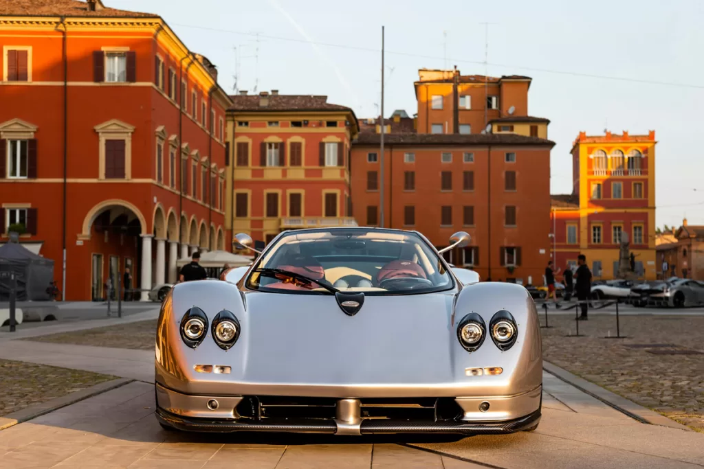 A luxury car sits on a cobblestoned piazza in Modena, Italy.