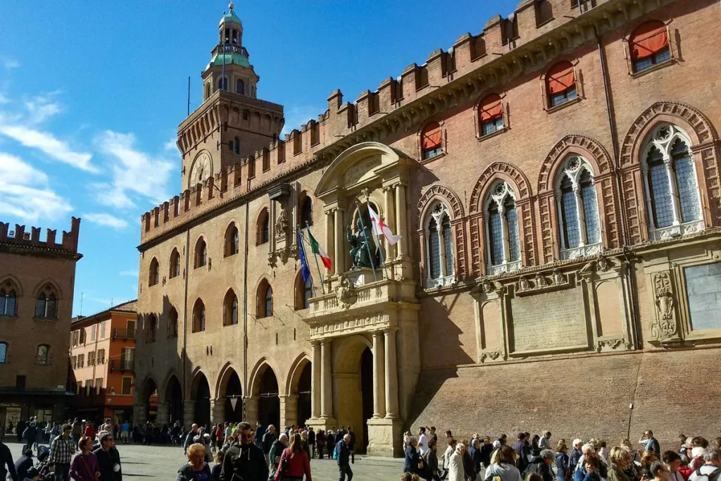 Tourists gather in the main square in Bologna, Italy, in front of the city's medieval Palazzo d'Accursio.