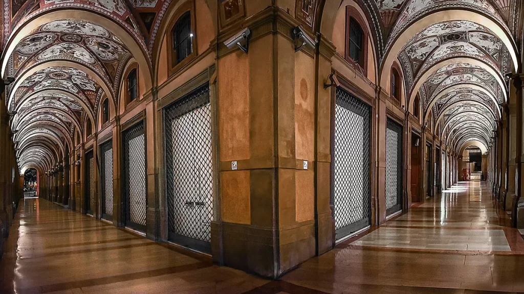 The intricately-decorated frescoes of the Piazza Cavour porticos are illuminated at night in Bologna, Italy.