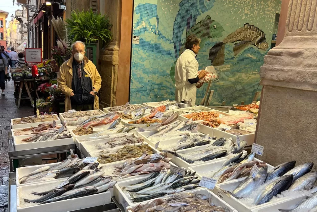 A man stands over the day's fresh fish catch at the medieval Quadrilatero food market in Bologna, Italy.