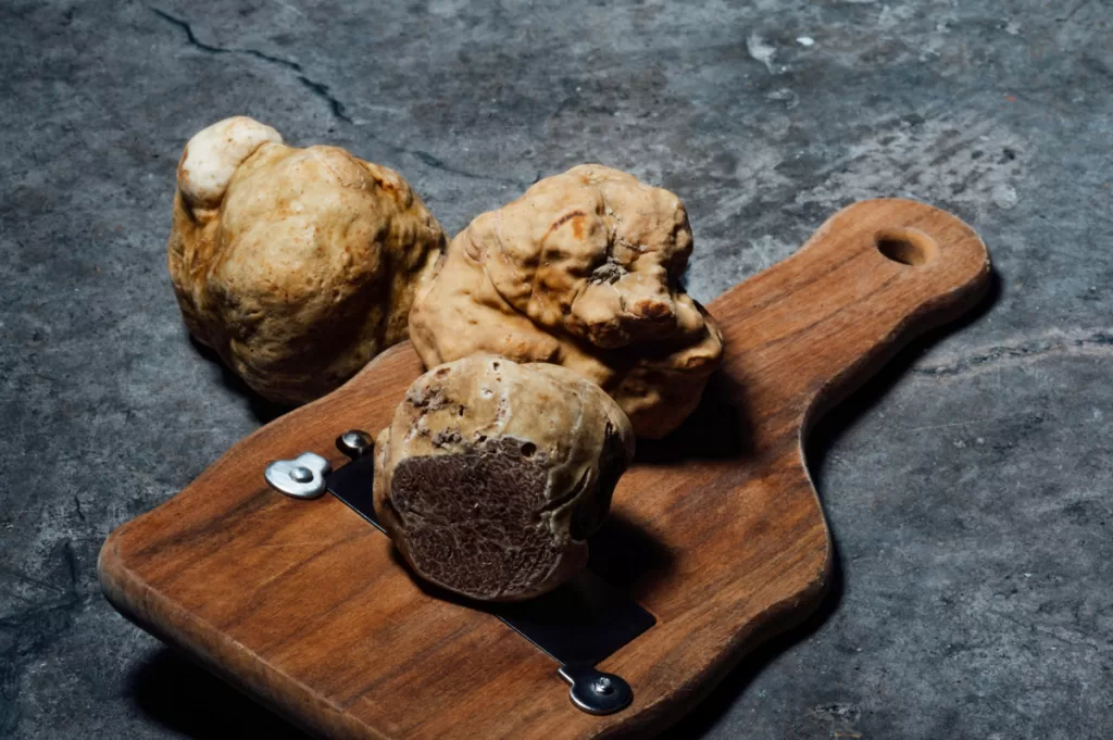 White truffles rest on a wood serving tray.