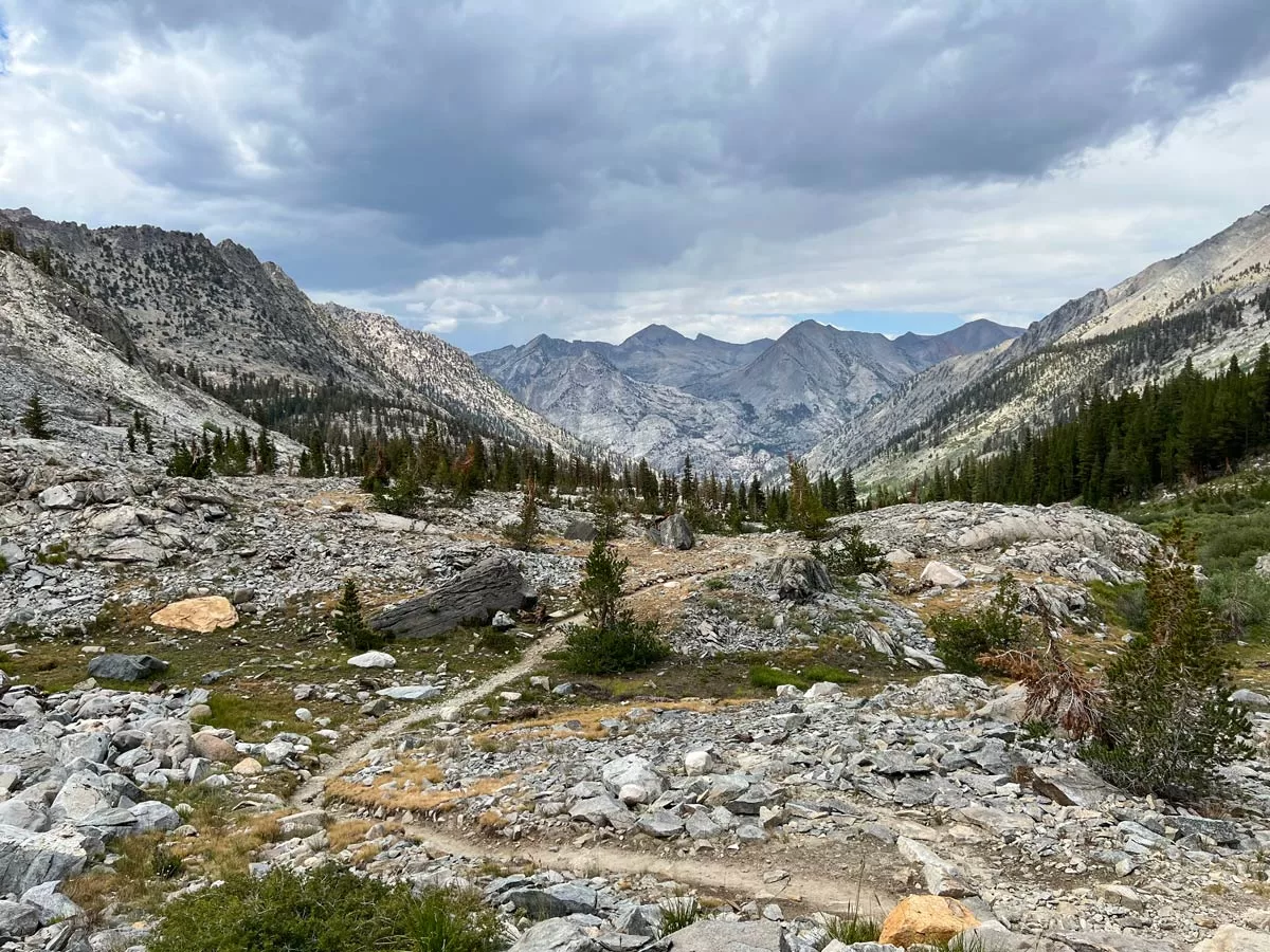 A small footpath winds along a rocky, windswept ridge above the tree line along the Rae Lakes Loop in Kings Canyon National Park.
