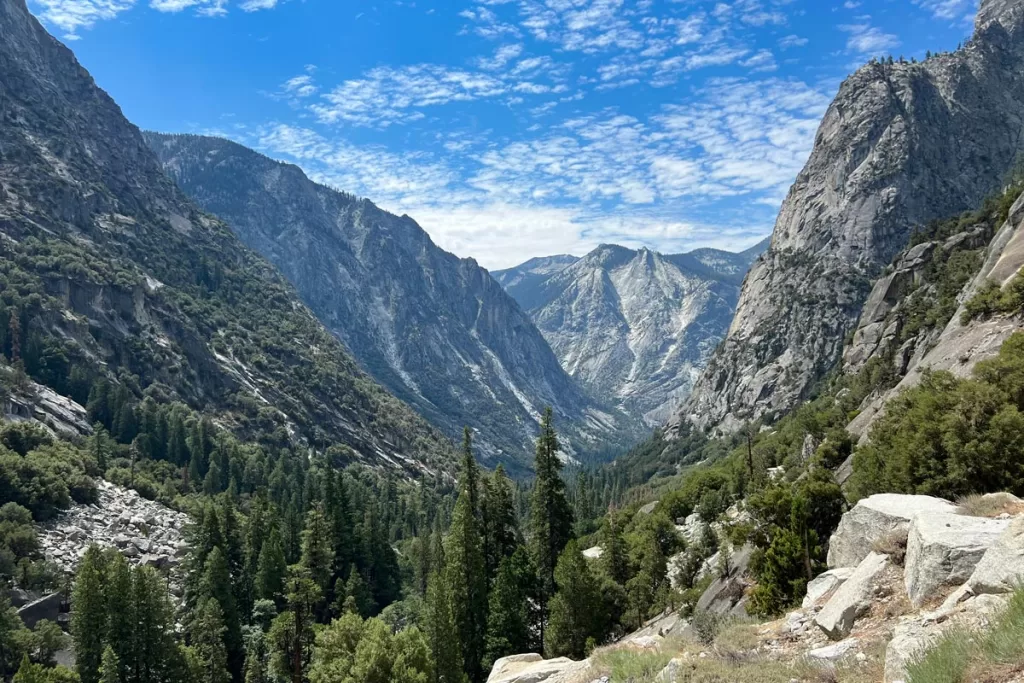 The granite monolith known as the Sphinx is seen from across a jagged valley of conifer trees on the Mist Falls Trail in Kings Canyon National Park.