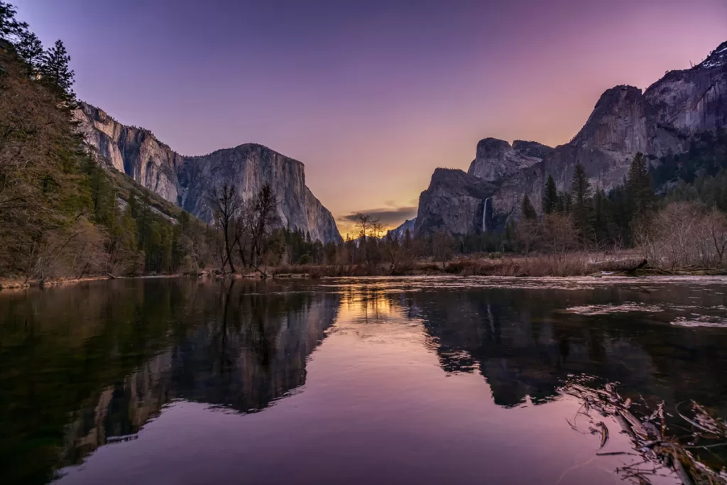 Yosemite National Park's El Capitan and Bridalveil Fall are reflected in the still waters of the Merced River at dusk, as seen from the Valley View outlook.