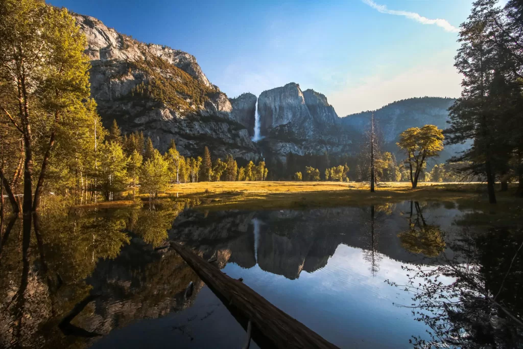 Yosemite Falls is reflected in the still waters of the Merced River in Yosemite Valley.