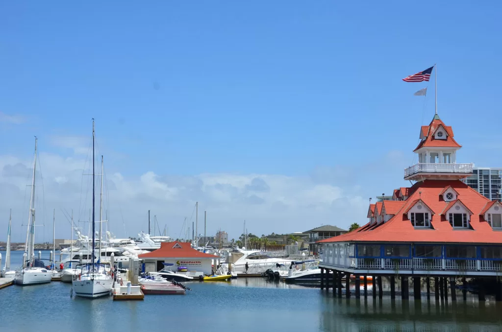 The Coronado Boat House, with its iconic red roof, rises above the calm waters of Glorietta Bay in Coronado, California.