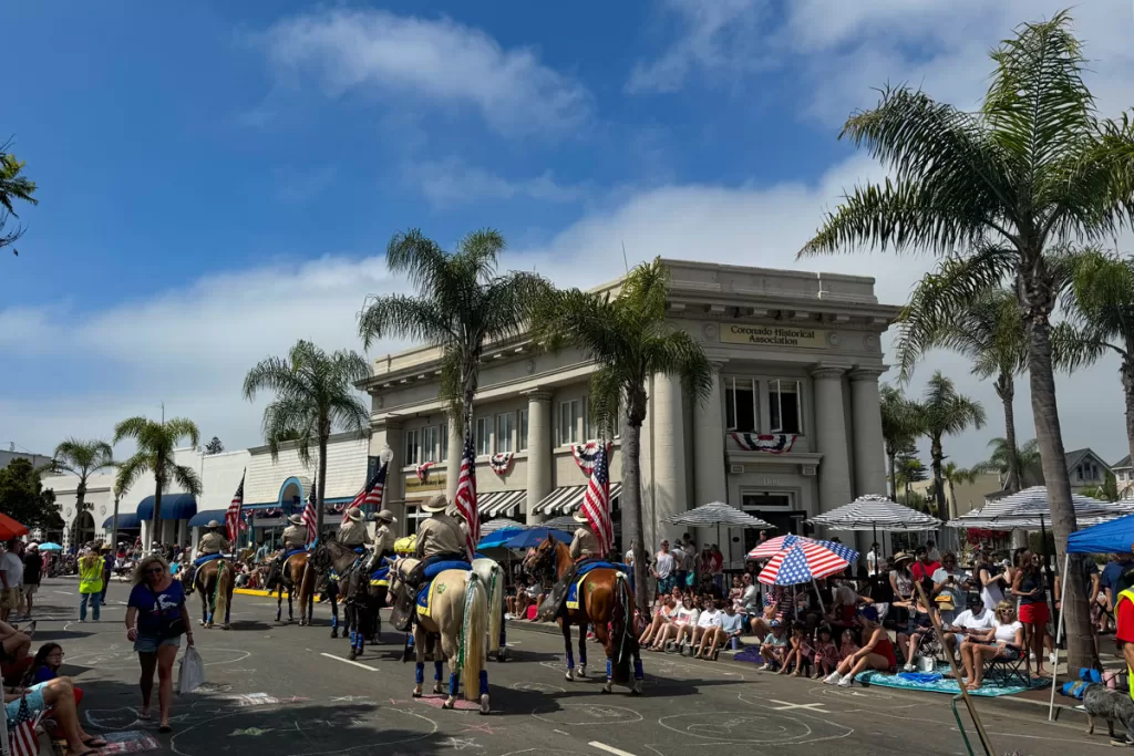 Mounted horsemen hold American flags and stand at attention during the annual Fourth of July parade in Coronado, California.