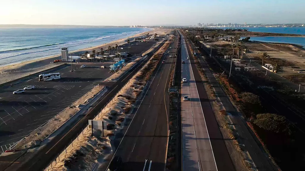 Cars pass along Highway 75, the narrow spit of land separating the Pacific Ocean from San Diego Bay by Silver Strand State Beach.
