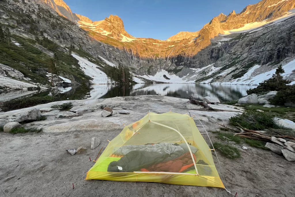 A small backpacking tent sits on an outcropping overlooking Hamilton Lake in California's Sierra Nevada mountains.