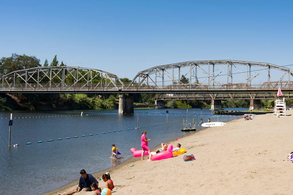 Families lounge on the sandy banks of Veterans Memorial Beach, along the Russian River in Healdsburg, California.
