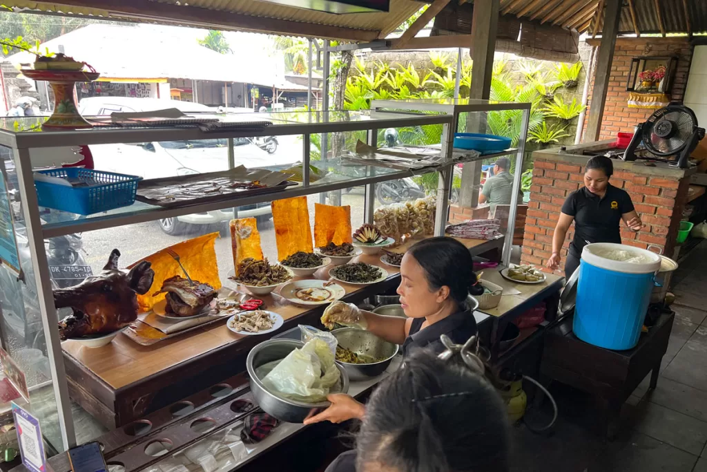 Women staff a traditional Indonesian food stall in Canggu, Bali, Indonesia