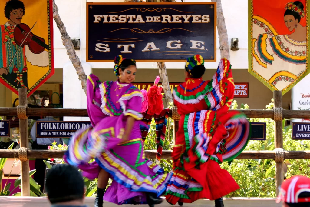 Two female folklorico dancers twirl on the Fiesta de Reyes stage in Old Town, San Diego.