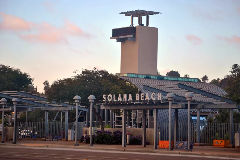 The train station in Solana Beach, California is warmed by a pink sunset.
