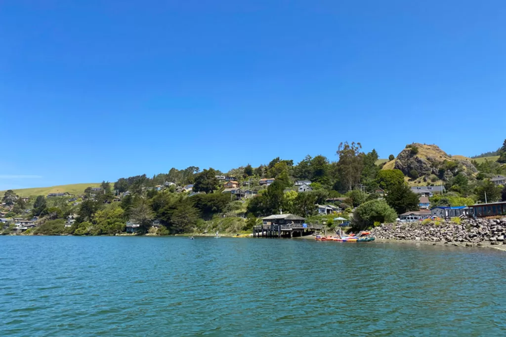 Small buildings line the shoreline of the Russian River in Jenner, California.